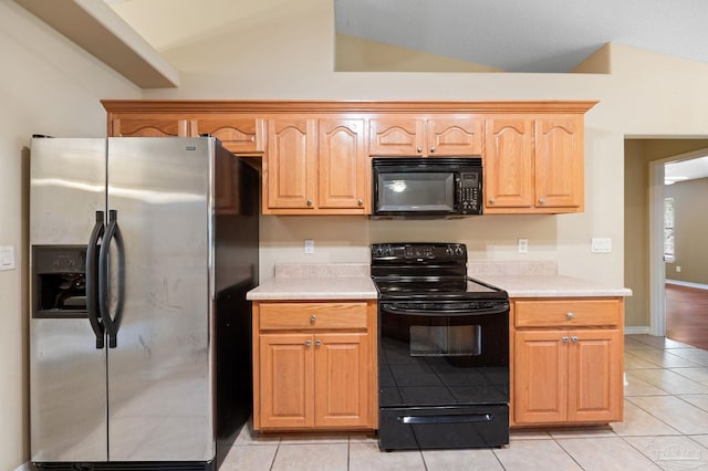 kitchen with baseboards, lofted ceiling, light tile patterned flooring, black appliances, and light countertops