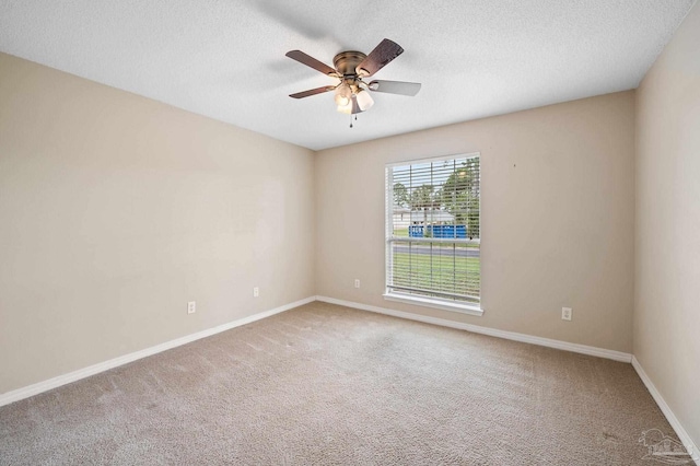 carpeted empty room with a textured ceiling, baseboards, and ceiling fan