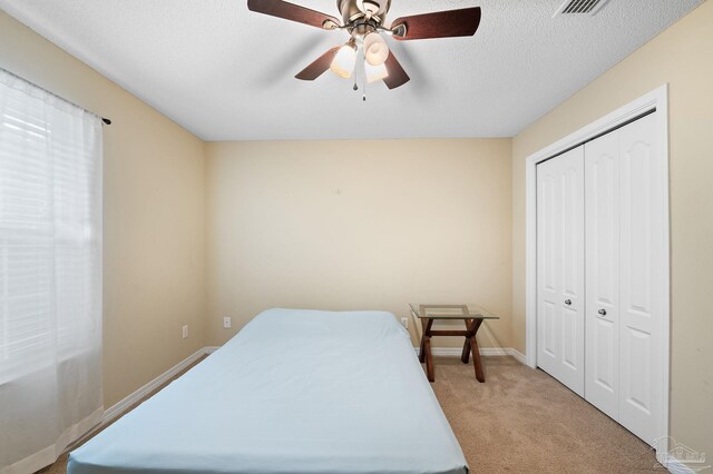 carpeted bedroom with a textured ceiling and ceiling fan