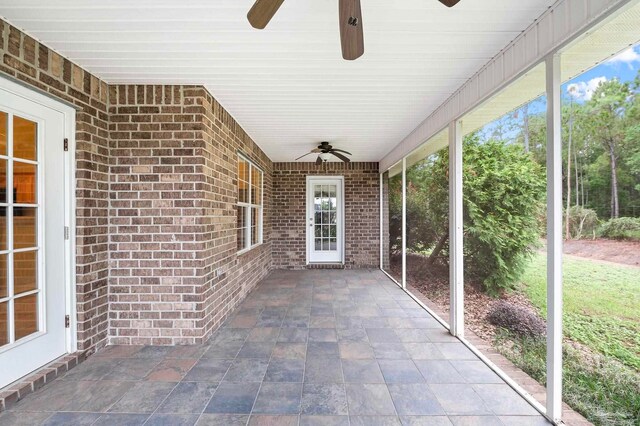 unfurnished sunroom with ceiling fan