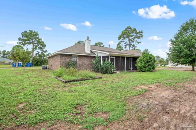 back of house with cooling unit, a yard, and a sunroom