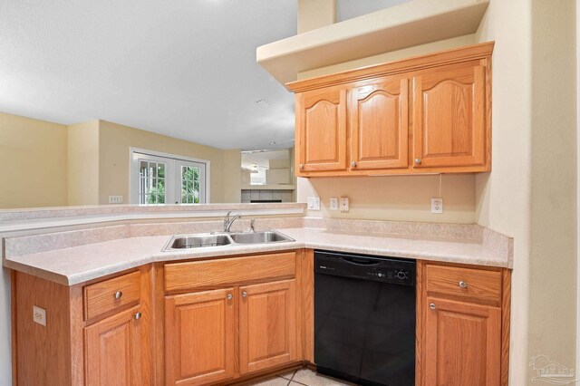 kitchen with light tile patterned floors, dishwasher, kitchen peninsula, and sink