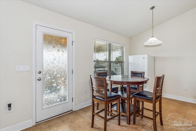 dining space featuring vaulted ceiling and light tile patterned floors