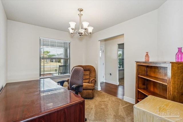 carpeted office featuring a chandelier