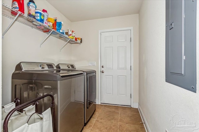 laundry room featuring washing machine and dryer, light tile patterned flooring, and electric panel