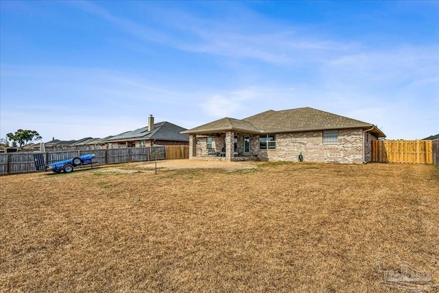 rear view of house featuring a yard