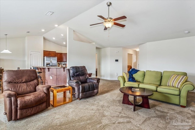 carpeted living room with ceiling fan and high vaulted ceiling