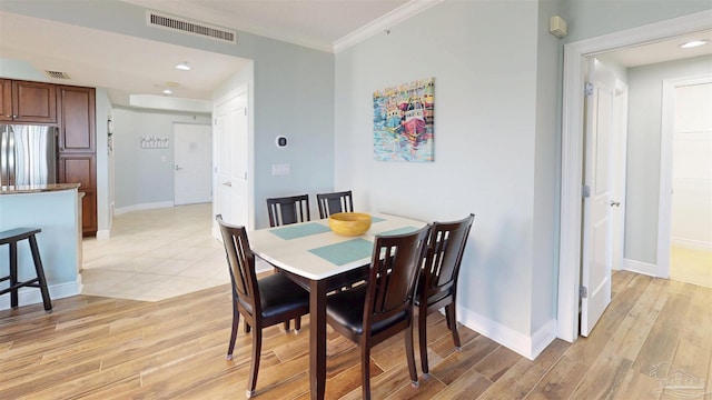 dining area with light wood-style floors, ornamental molding, baseboards, and recessed lighting