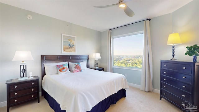 bedroom featuring light carpet, baseboards, and a ceiling fan