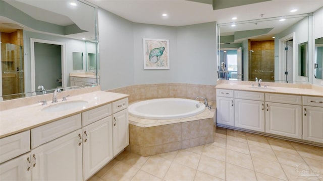 bathroom with tile patterned flooring, a stall shower, a bath, two vanities, and recessed lighting