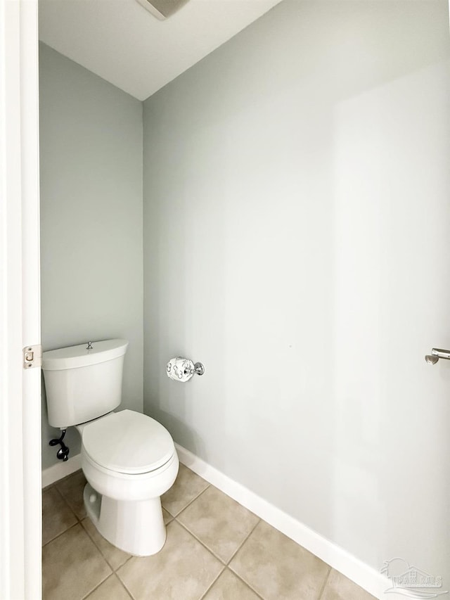 bathroom featuring toilet, tile patterned floors, and baseboards