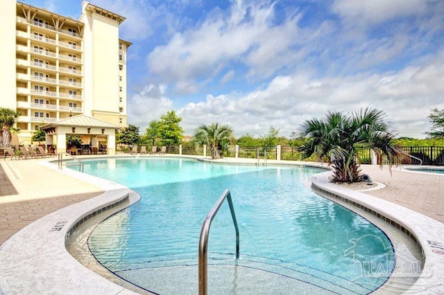 community pool featuring fence and a patio area