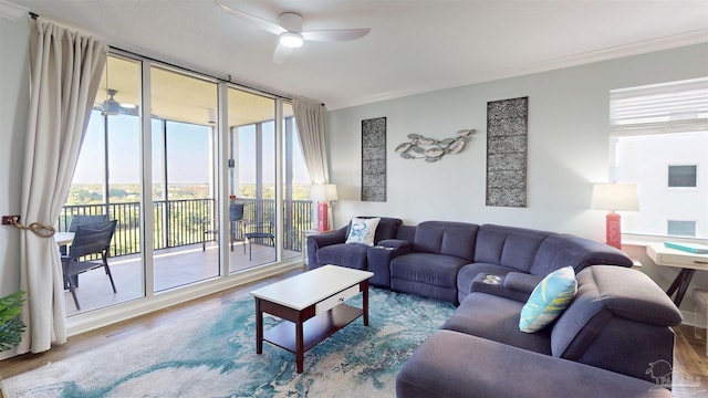 living room featuring ceiling fan, wood finished floors, crown molding, and floor to ceiling windows