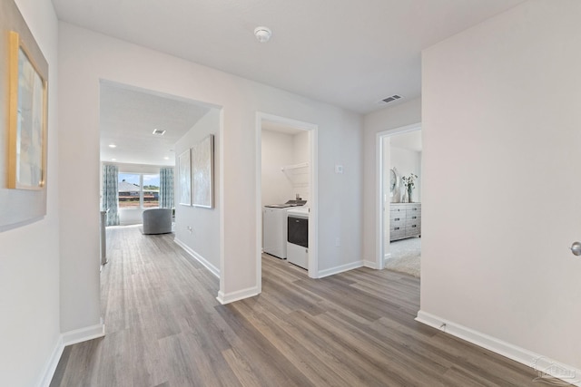 hall with light hardwood / wood-style floors and washer / dryer