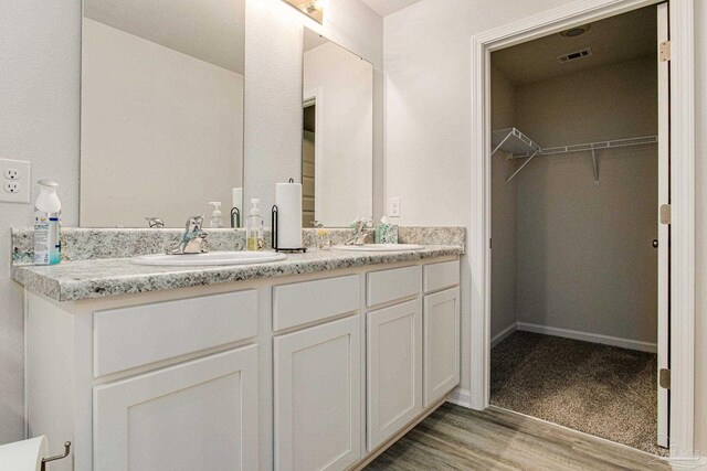 kitchen featuring sink, light hardwood / wood-style flooring, appliances with stainless steel finishes, light stone counters, and white cabinetry