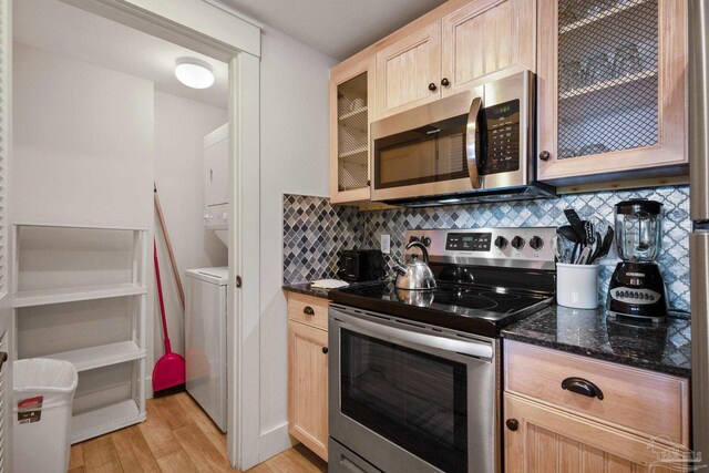 kitchen featuring sink, dishwasher, ceiling fan with notable chandelier, and dark stone counters