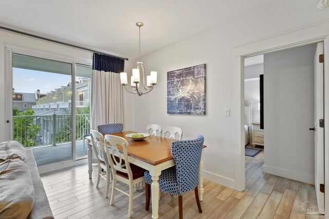 dining area with ceiling fan with notable chandelier and light hardwood / wood-style floors