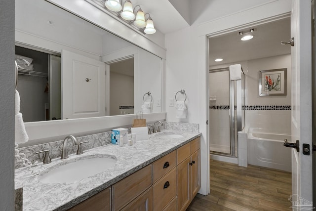 bathroom with plus walk in shower, wood-type flooring, and dual bowl vanity