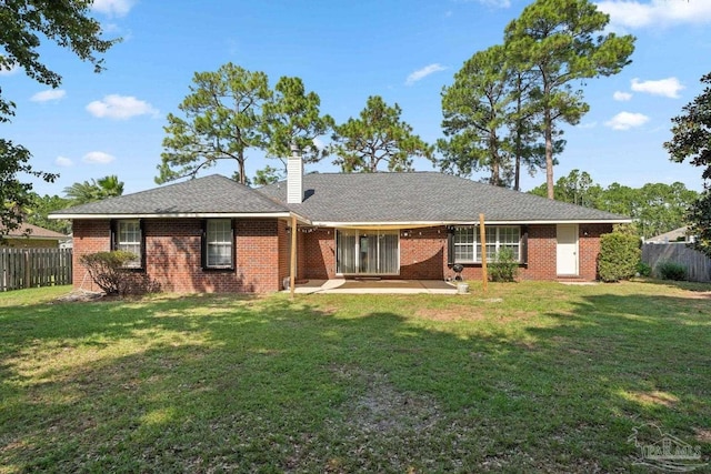 back of property with a patio, fence, brick siding, and a chimney