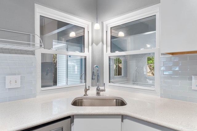 kitchen with white cabinetry, sink, decorative light fixtures, and plenty of natural light