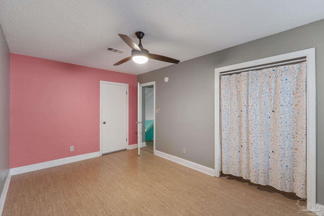 unfurnished bedroom featuring a textured ceiling and ceiling fan