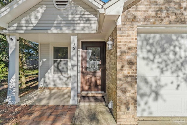 property entrance with covered porch and a garage