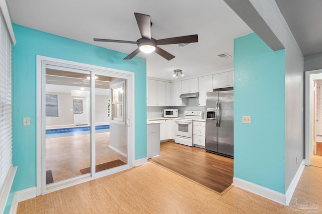 kitchen featuring white appliances, light hardwood / wood-style floors, white cabinetry, and ceiling fan