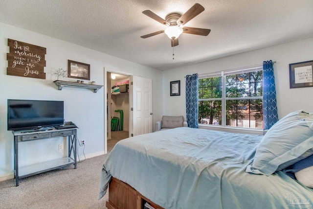 bedroom with a textured ceiling, baseboards, a ceiling fan, and light colored carpet