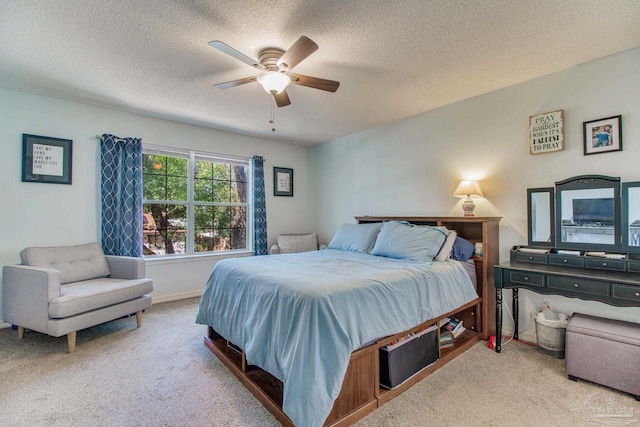 bedroom with light carpet, ceiling fan, and a textured ceiling