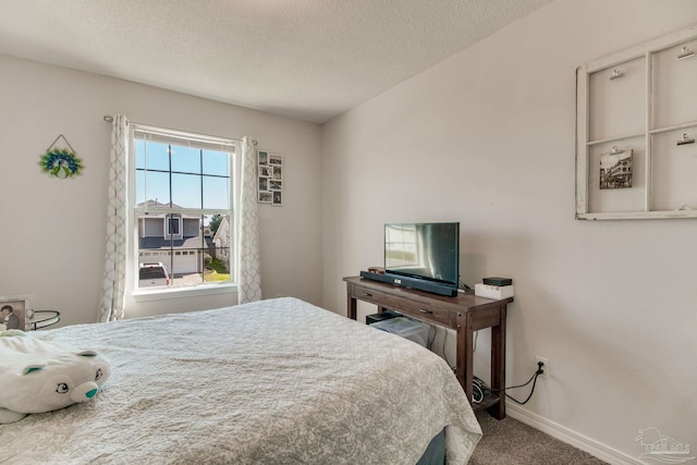 carpeted bedroom featuring baseboards and a textured ceiling