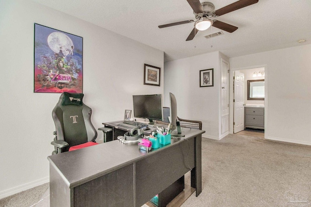 office area featuring light carpet, baseboards, visible vents, and ceiling fan