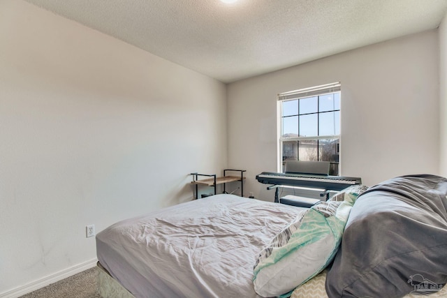 bedroom featuring a textured ceiling, carpet flooring, and baseboards