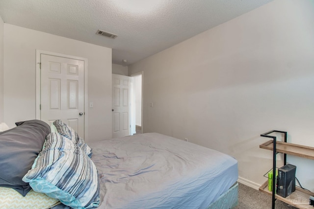 bedroom featuring carpet, visible vents, a textured ceiling, and baseboards