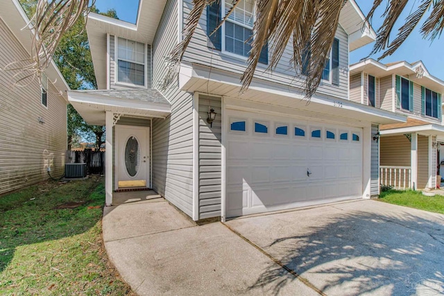 entrance to property with an attached garage, driveway, and cooling unit