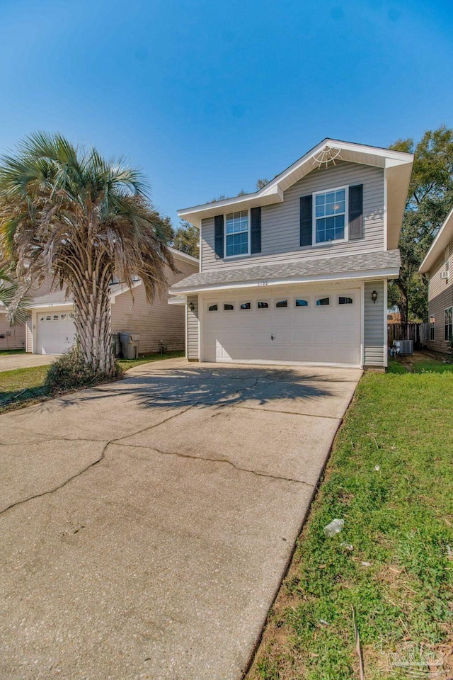 traditional home featuring central AC, driveway, and an attached garage