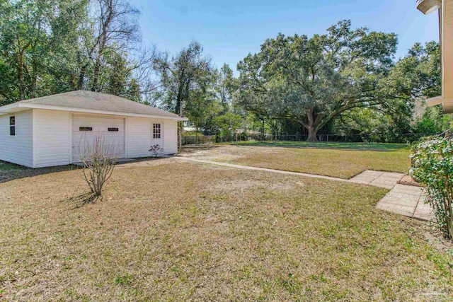 view of yard with a garage and an outbuilding