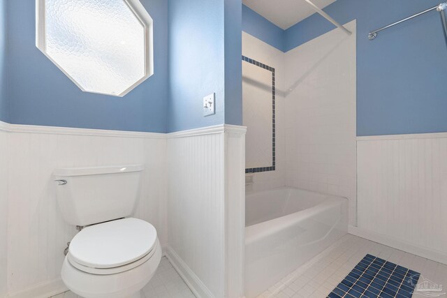 bathroom with toilet, tile patterned floors, and tiled shower / bath