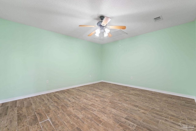 spare room featuring wood-type flooring, ceiling fan, and a textured ceiling