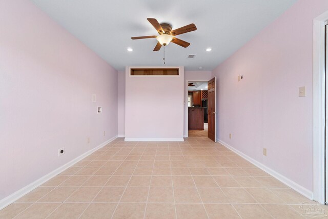 tiled spare room featuring ceiling fan