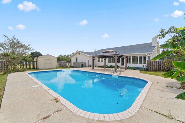 view of swimming pool featuring a storage unit, a patio, and a gazebo