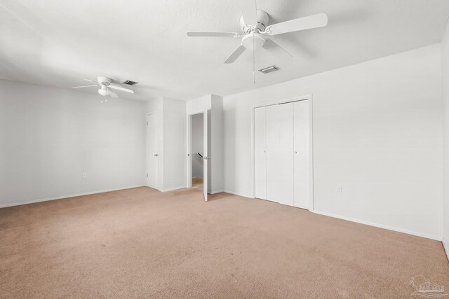 unfurnished bedroom featuring light carpet, ceiling fan, and visible vents