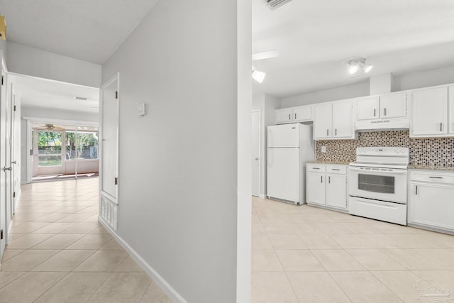 kitchen featuring white appliances, tasteful backsplash, under cabinet range hood, white cabinetry, and light tile patterned flooring