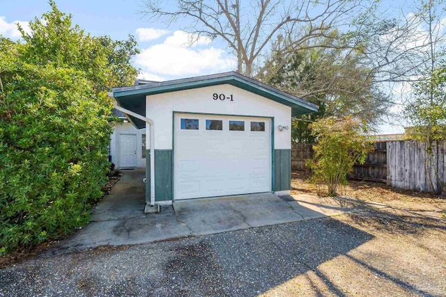 garage with driveway and fence