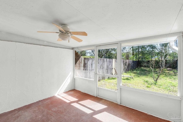 unfurnished sunroom featuring a ceiling fan