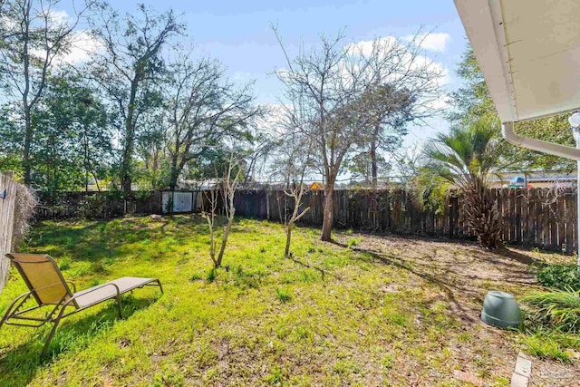 view of yard featuring a shed, an outdoor structure, and a fenced backyard