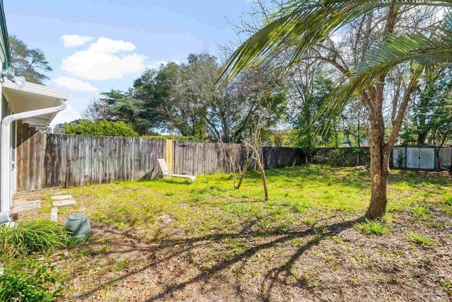 view of yard with an outbuilding, a shed, and a fenced backyard