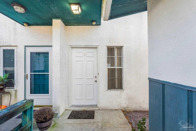 entrance to property featuring stucco siding