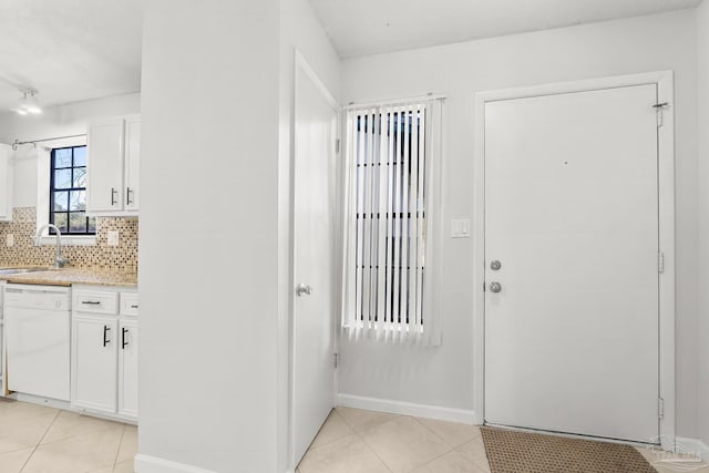 foyer featuring light tile patterned floors and baseboards