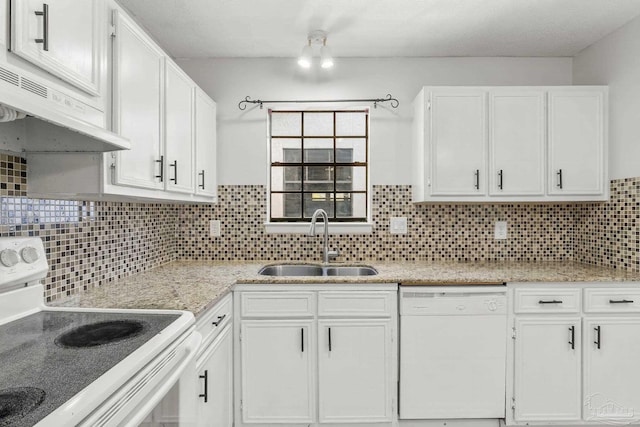 kitchen featuring white appliances, tasteful backsplash, under cabinet range hood, white cabinetry, and a sink