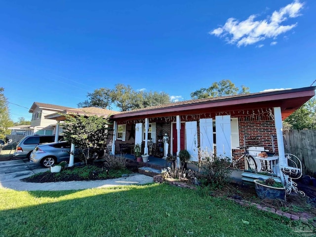 ranch-style home with a porch, brick siding, and a front lawn